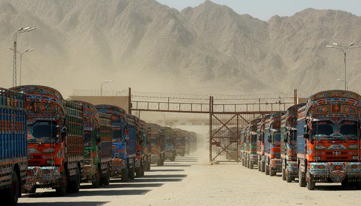 Длинная очередь грузовиков, остановившихся у закрытого пограничного перехода Торхам на границе Афганистана и Пакистана в горной местности.