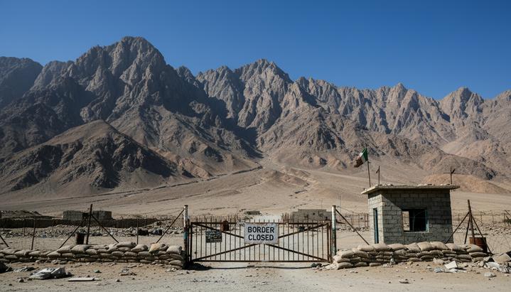 Засушливый горный пейзаж на границе Афганистана и Пакистана, пустынный пограничный переход с закрытыми воротами.